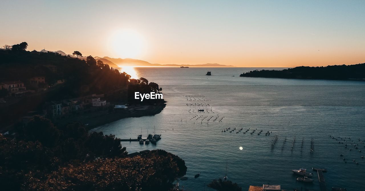 High angle view of bay against sky at sunset