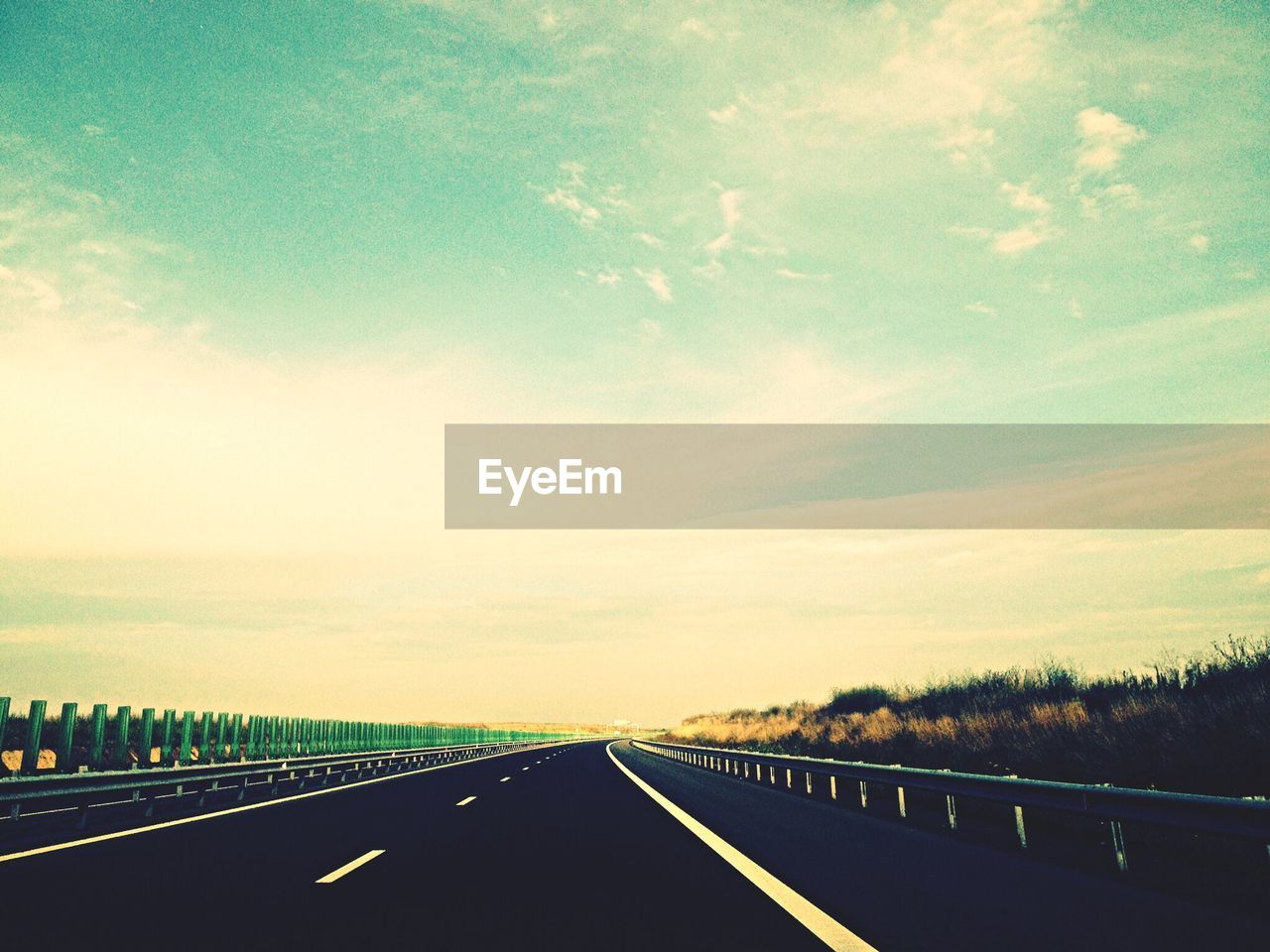 Empty road against cloudy sky