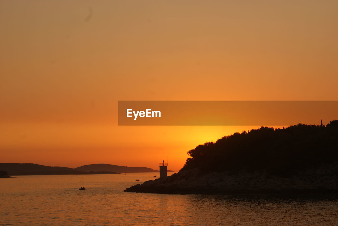 SCENIC VIEW OF SEA AGAINST ORANGE SUNSET SKY