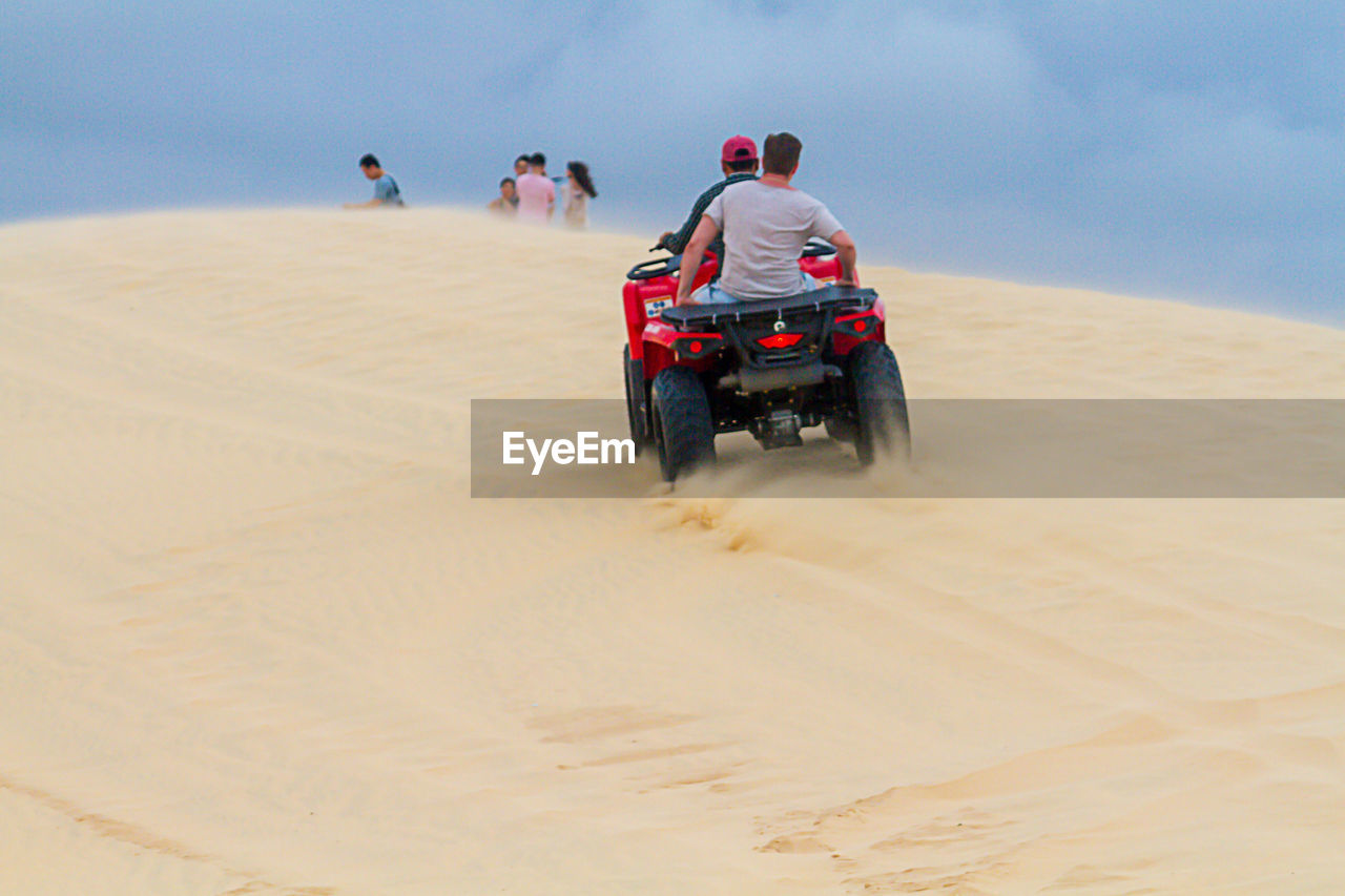 PEOPLE RIDING MOTORCYCLE IN DESERT