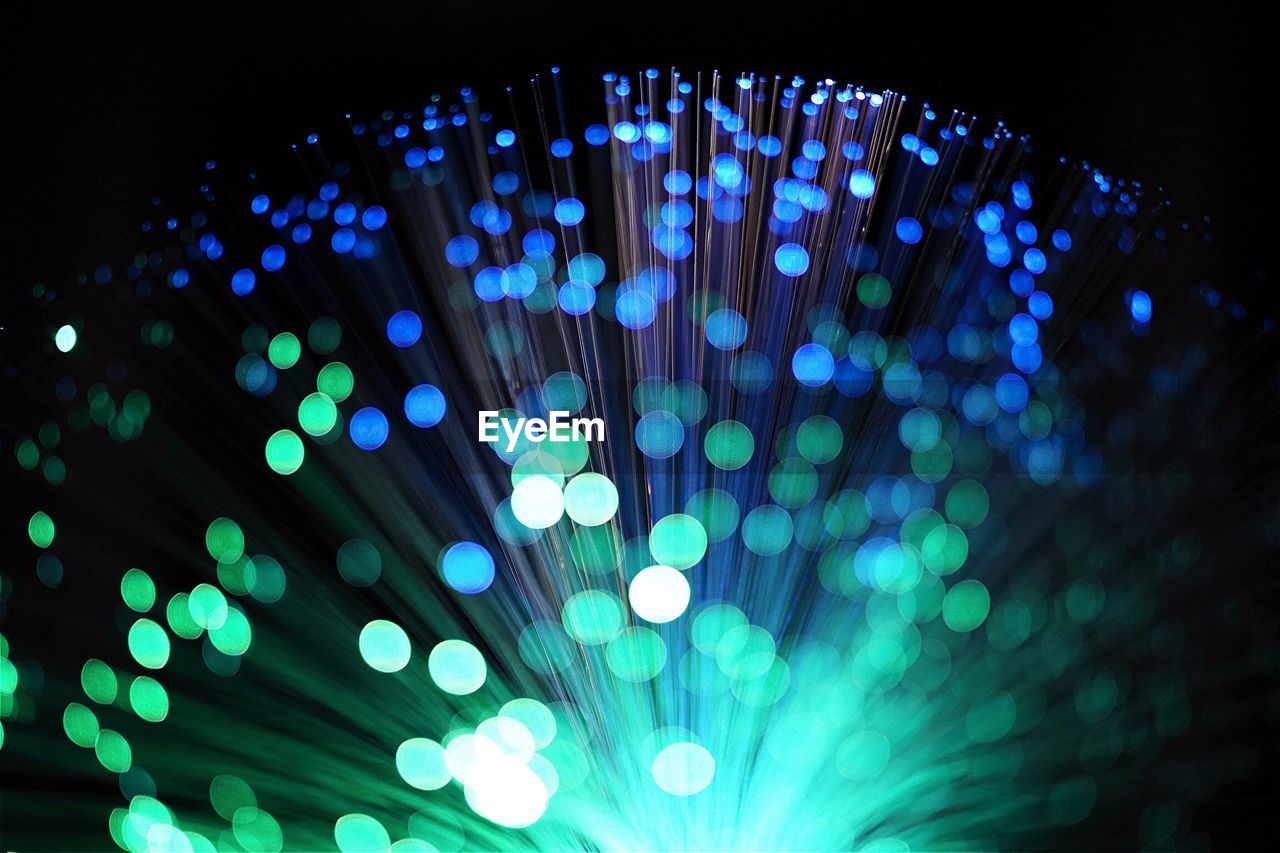 Close-up of illuminated fiber optic against black background