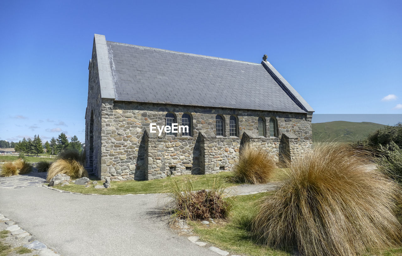 OLD BUILDING BY ROAD AGAINST CLEAR SKY