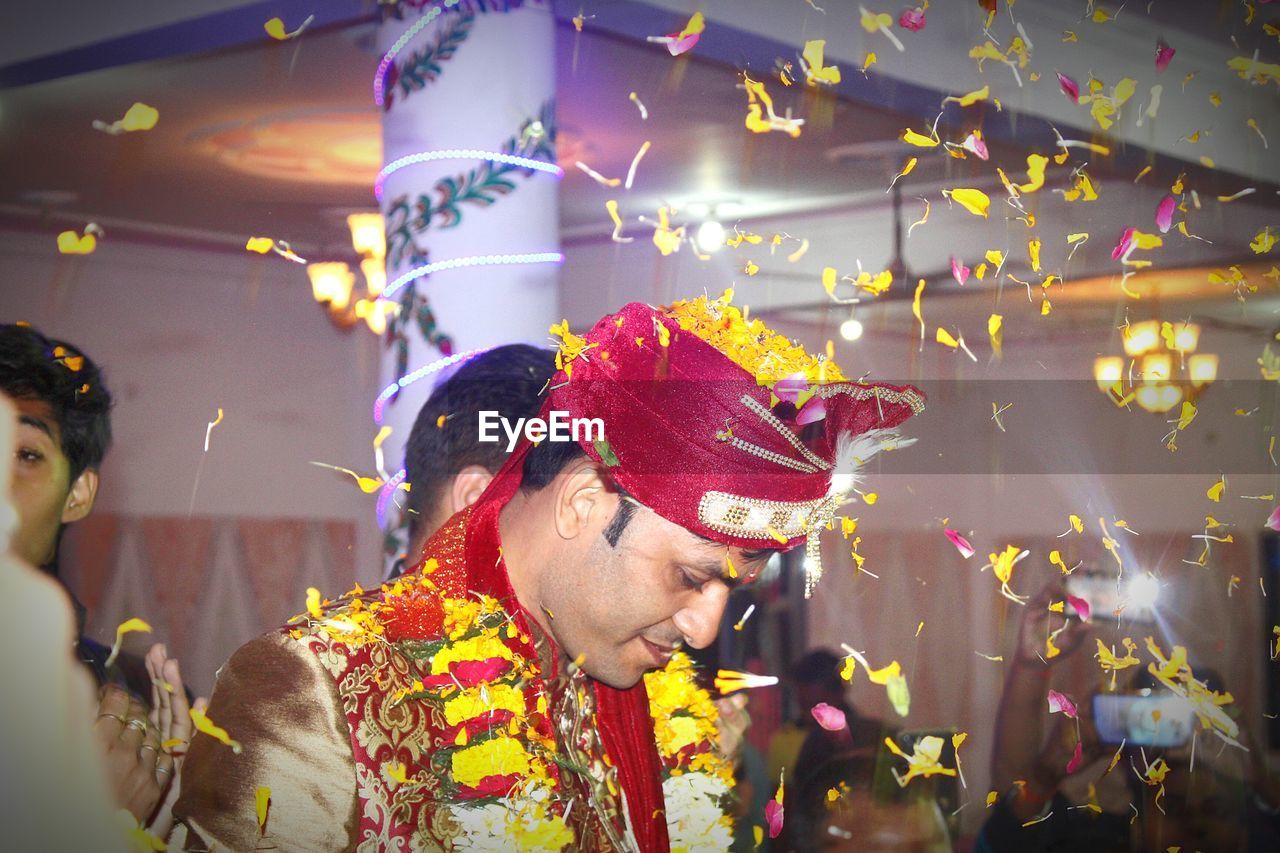 Close-up of groom amidst flowers during wedding ceremony