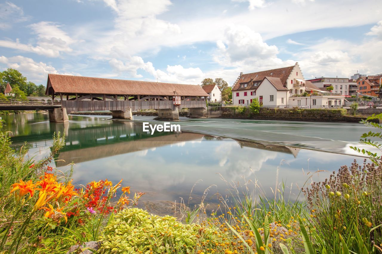 Scenic view of lake by buildings against sky