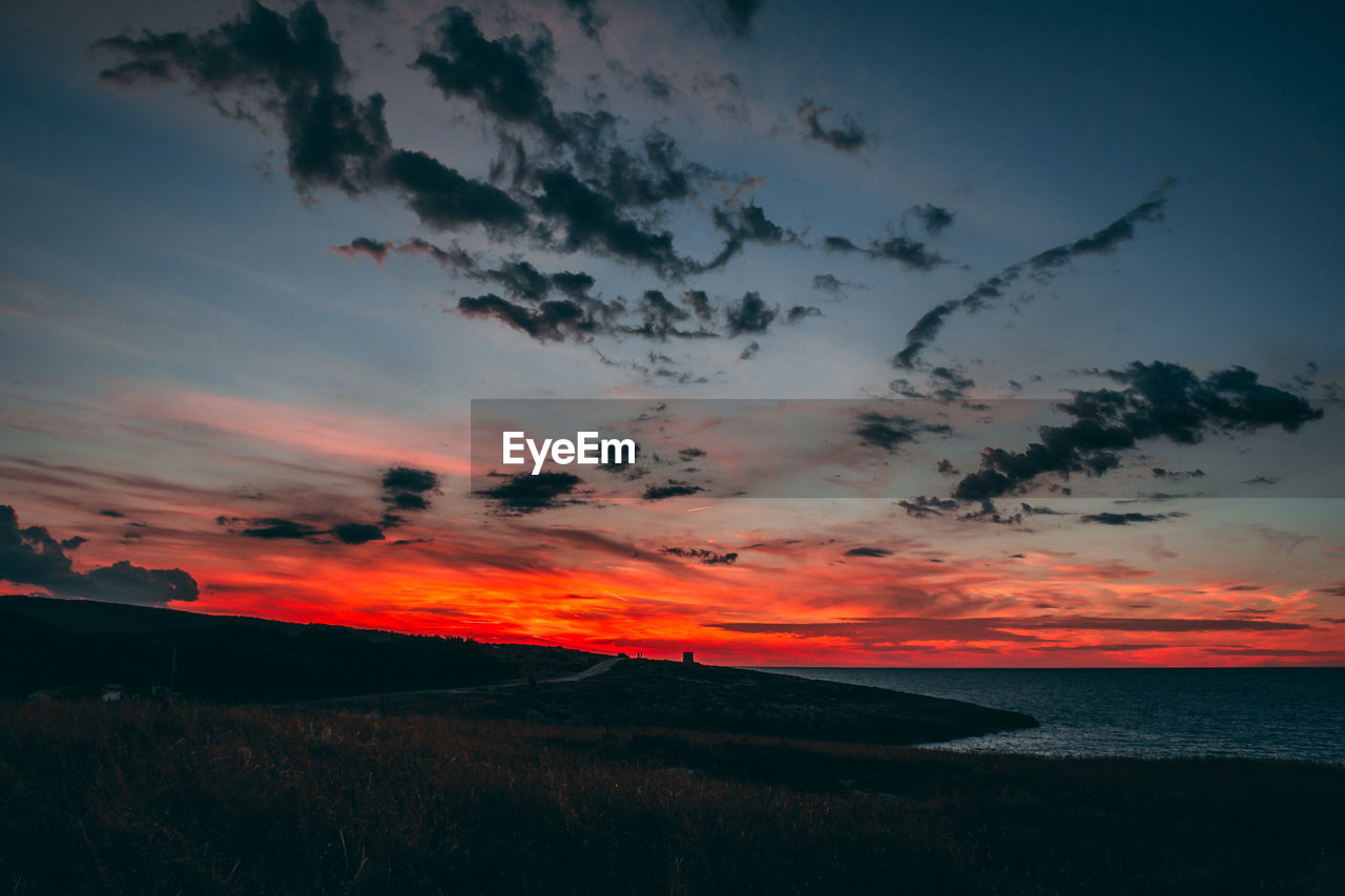 SCENIC VIEW OF SILHOUETTE SEA AGAINST SKY DURING SUNSET