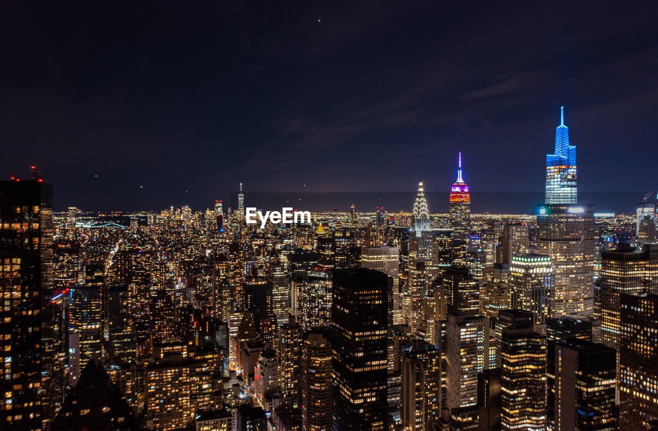 high angle view of illuminated cityscape against sky at night