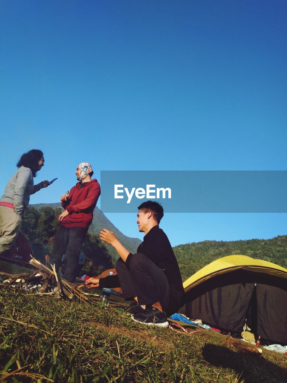 PEOPLE SITTING AGAINST BLUE SKY