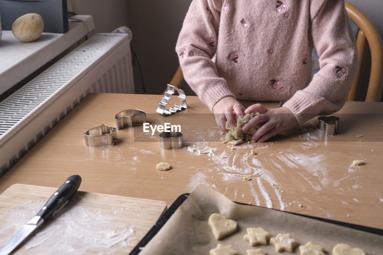 midsection of chef preparing gingerbread cookies on table