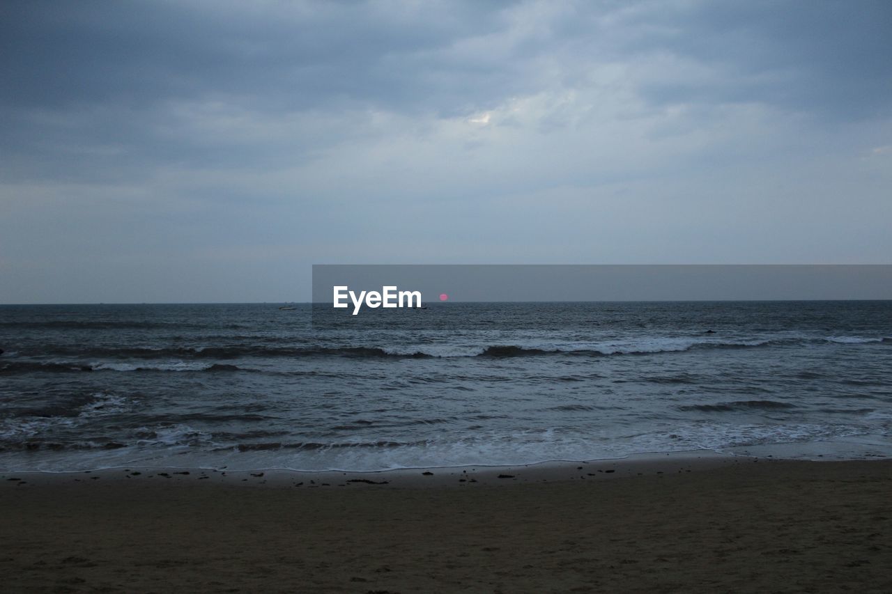 Scenic view of sea against cloudy sky