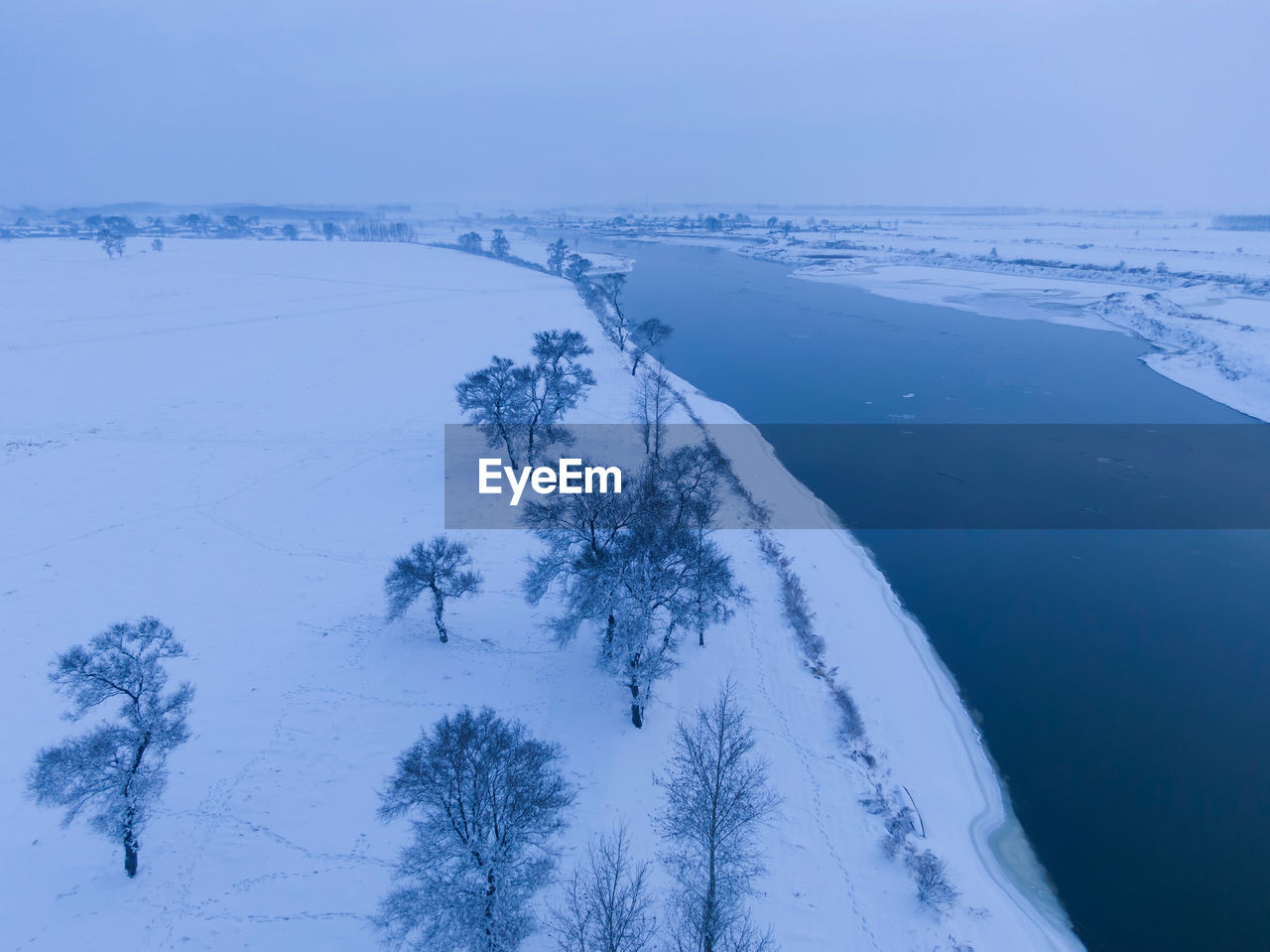 Scenic view of snow covered land against sky