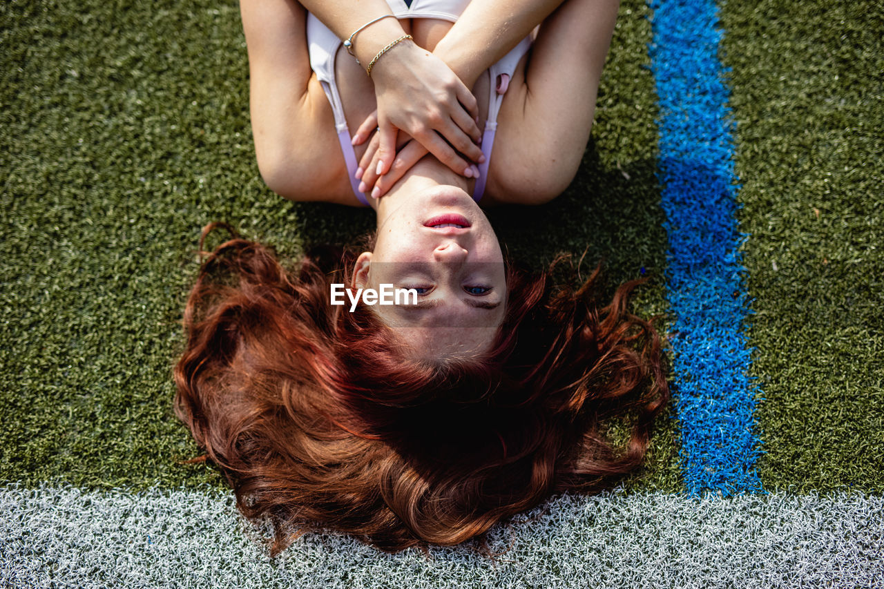 HIGH ANGLE VIEW OF WOMAN LYING DOWN ON FLOOR