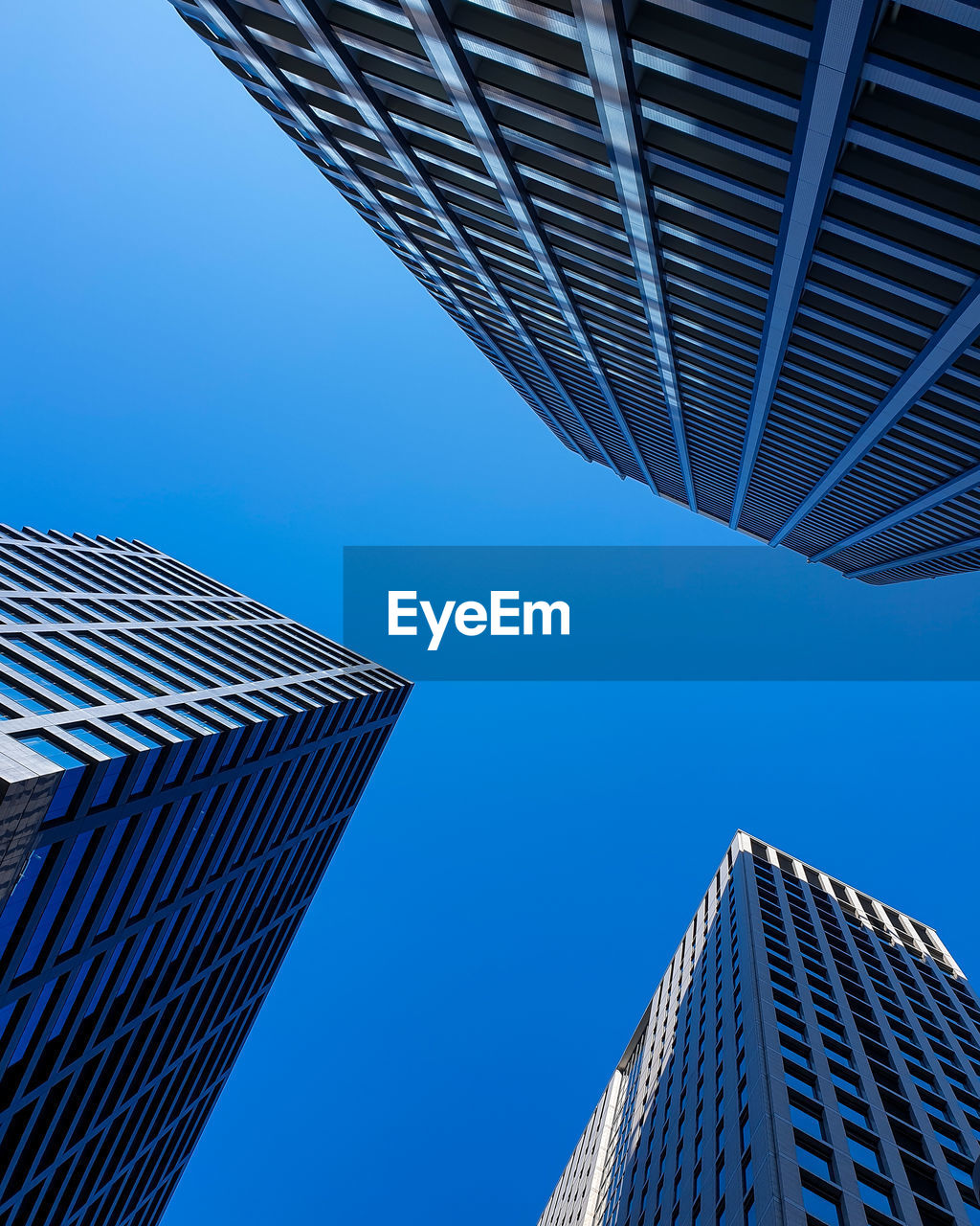 Low angle view of modern buildings against clear blue sky