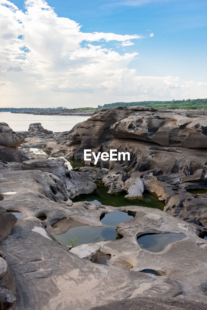 ROCKS ON SHORE AGAINST SKY