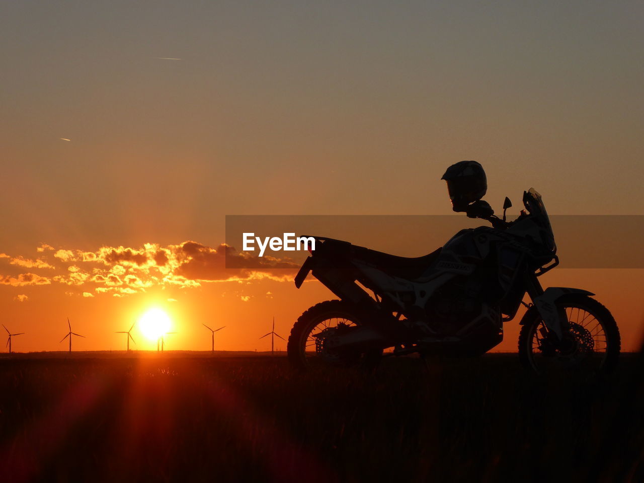 SILHOUETTE MAN RIDING BICYCLE AGAINST SKY DURING SUNSET