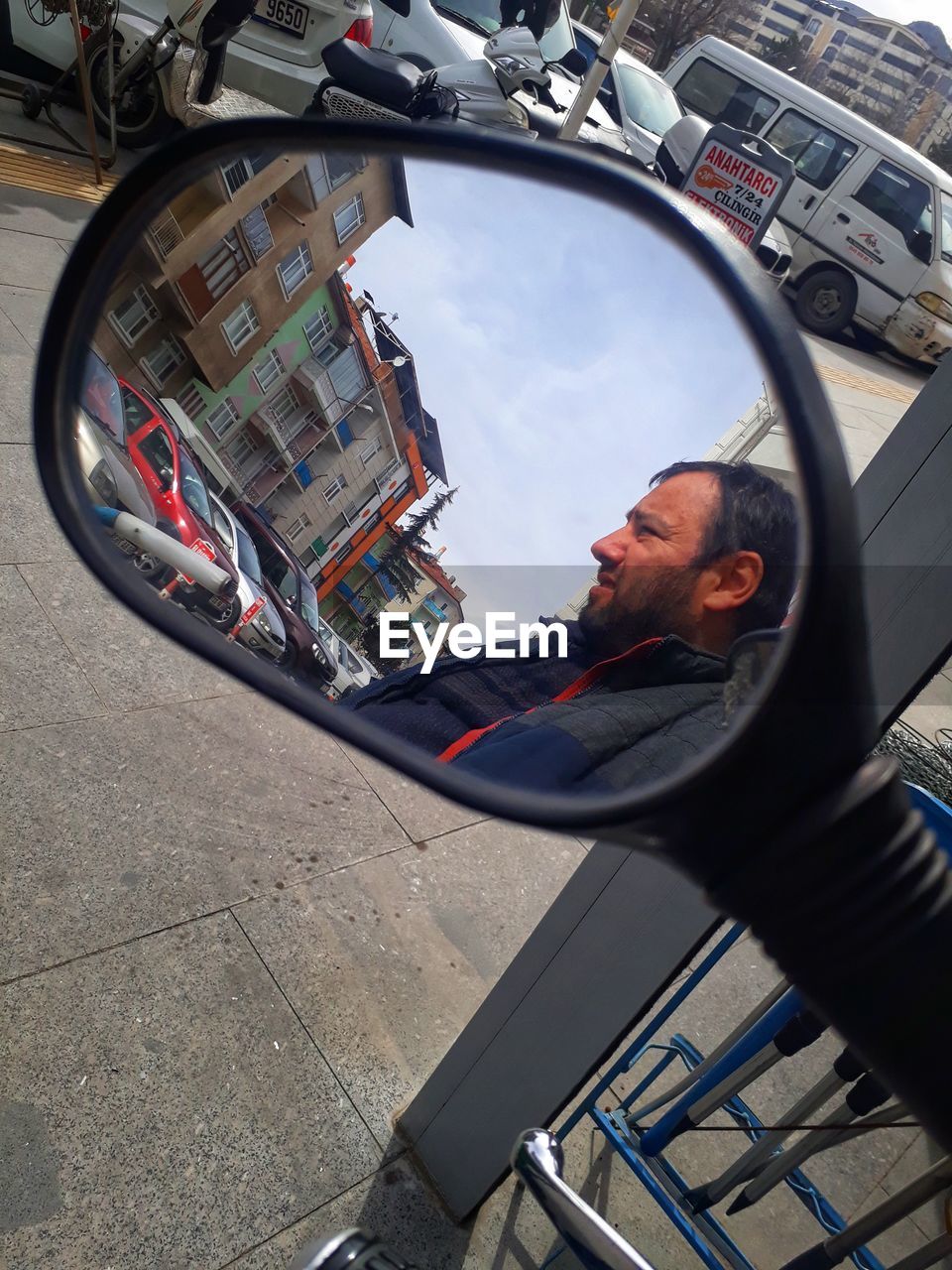 REFLECTION OF MAN PHOTOGRAPHING CAR ON MIRROR