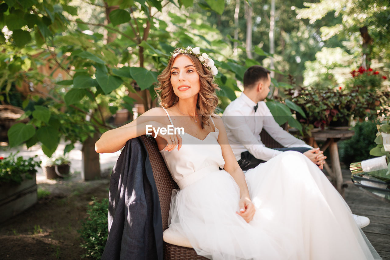 Bride and bridegroom sitting at park