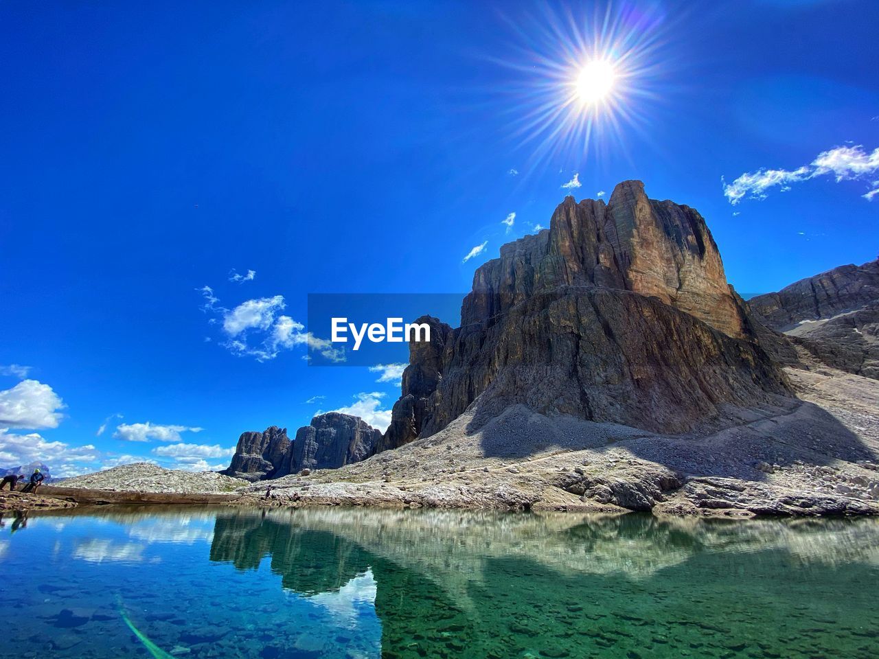 Mountain lake on dolomites - rock formations against blue sky