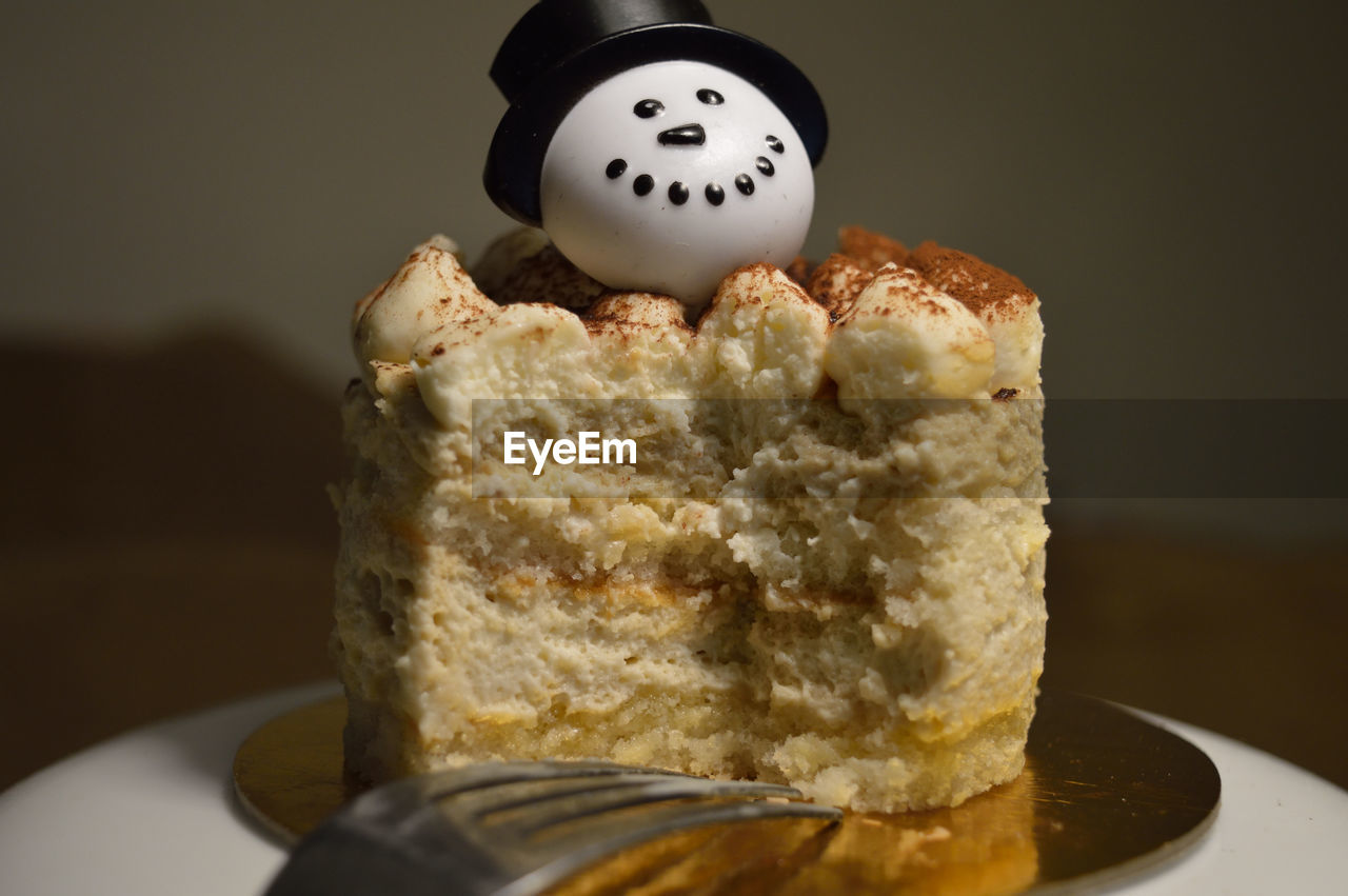 Close-up of dessert with snowman by fork