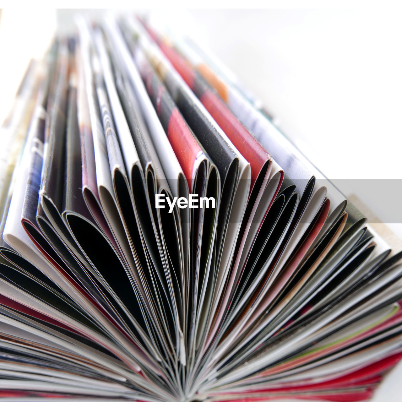 Close-up of magazines making pattern on white background