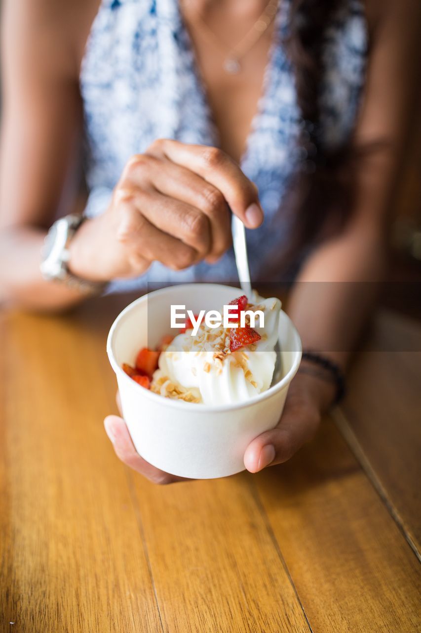 Midsection of woman holding ice cream in bowl