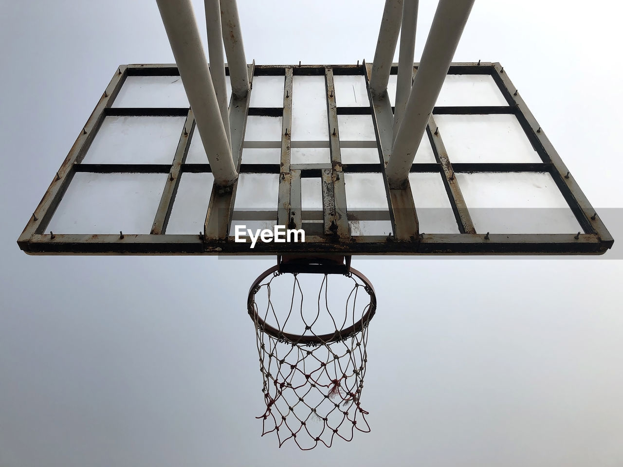 DIRECTLY BELOW SHOT OF BASKETBALL HOOP AGAINST SKY