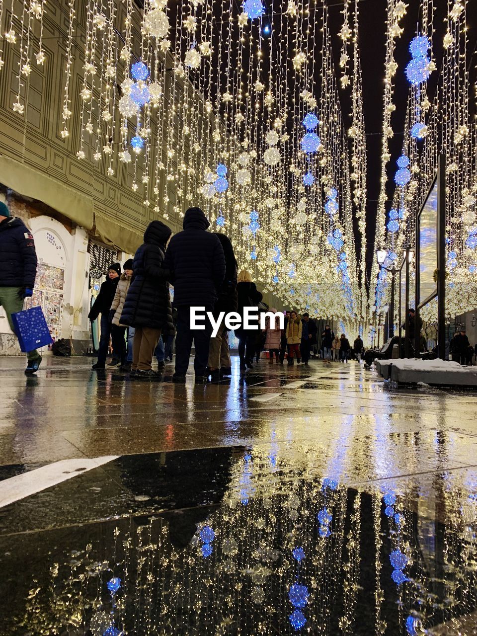 PEOPLE WALKING ON WET STREET IN RAINY SEASON