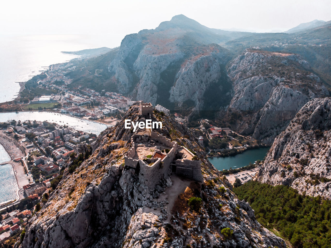 Aerial view of rock formation and pirate castle overlooking valley in omis, croatia. 