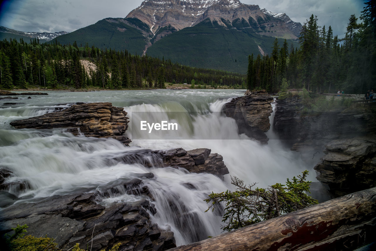 SCENIC VIEW OF WATERFALL AGAINST MOUNTAIN