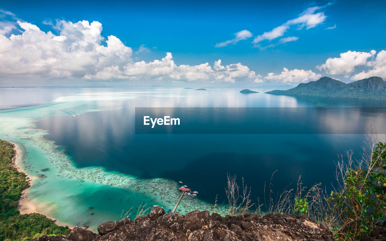 Scenic view of beach against cloudy sky