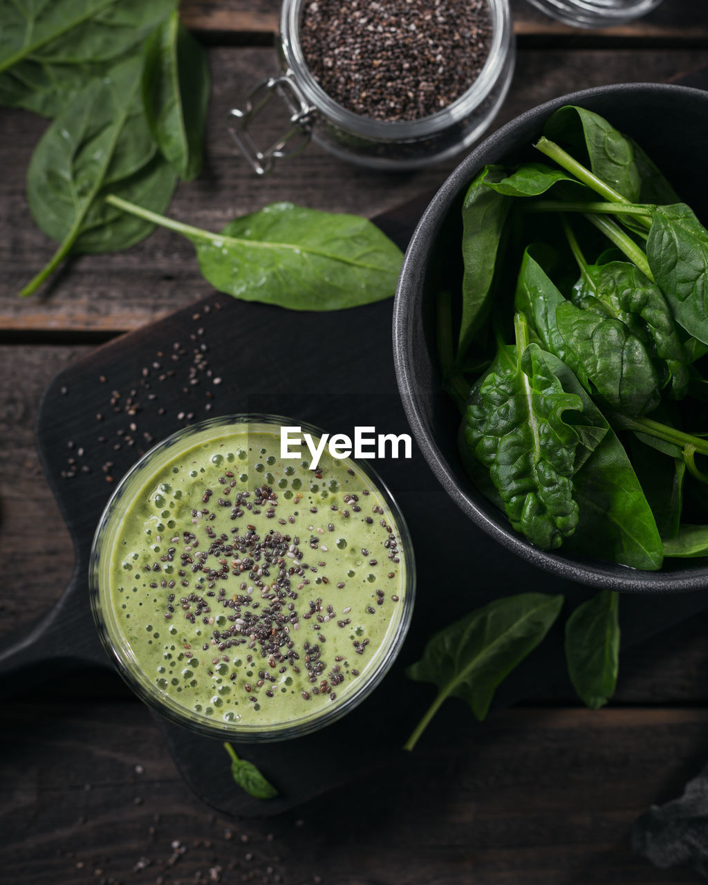 Glass of homemade healthy green smoothie with fresh baby spinach