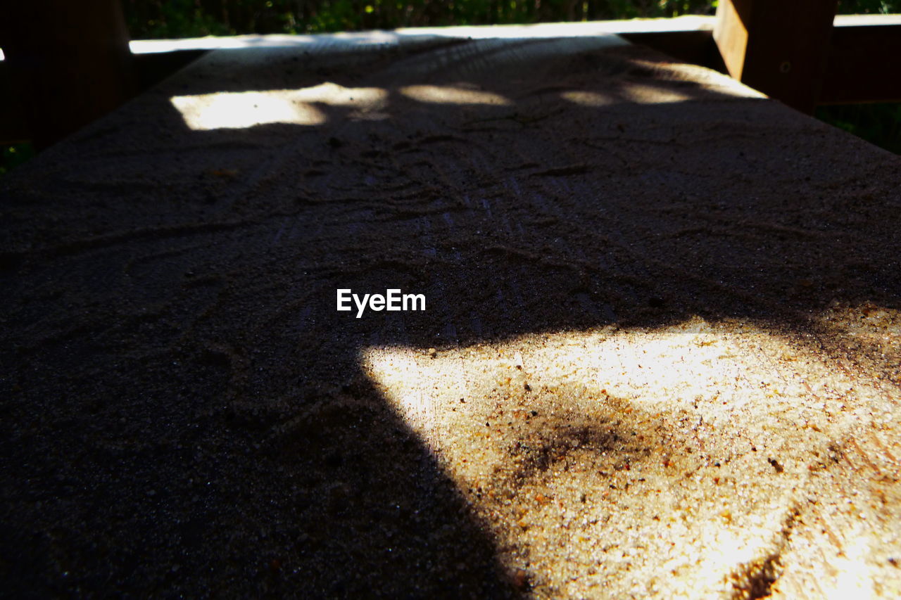 HIGH ANGLE VIEW OF SUNLIGHT FALLING ON STREET DURING SUNNY DAY