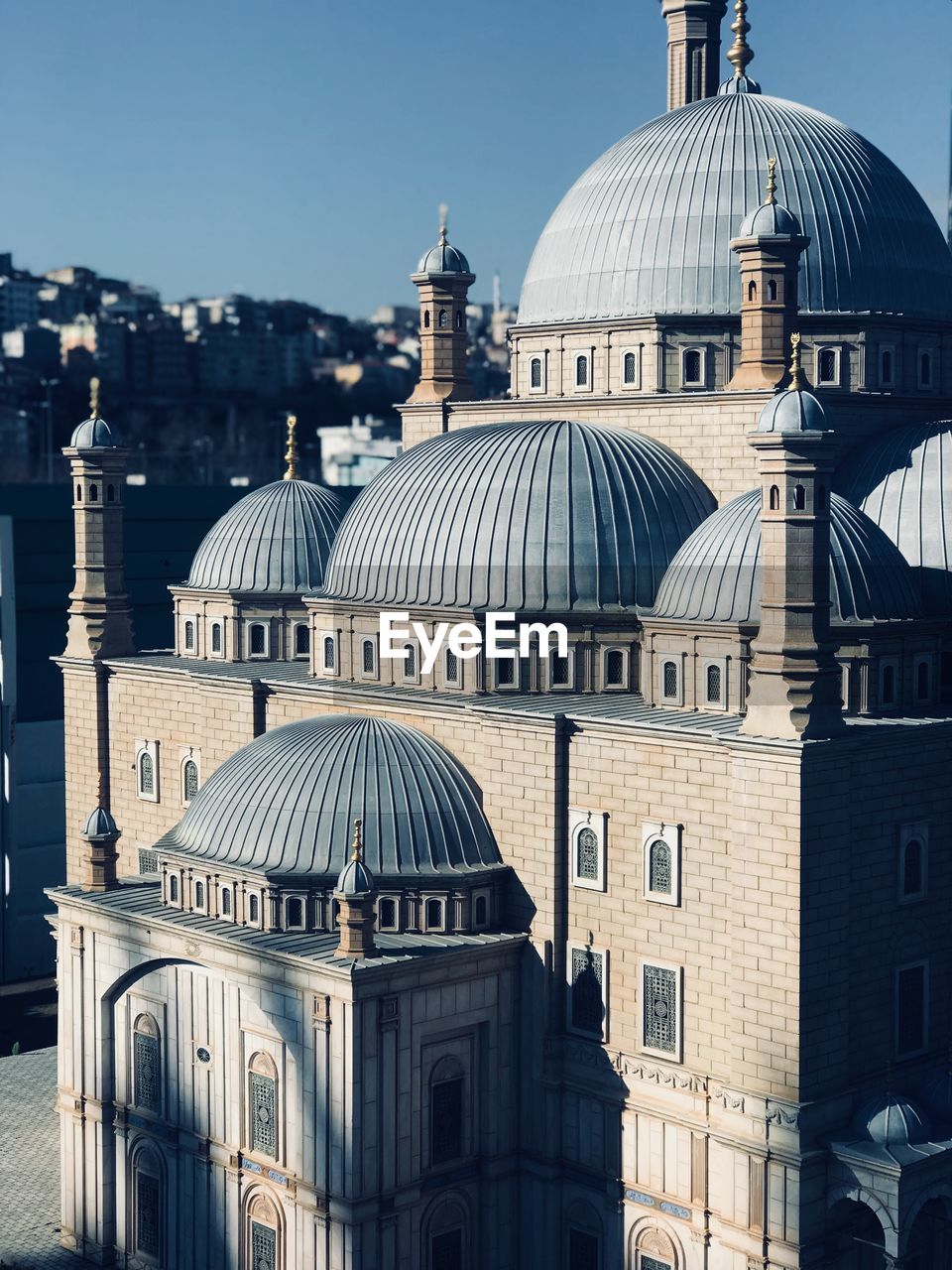 Mosque in city during sunny day