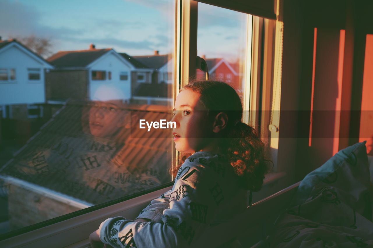 PORTRAIT OF BOY LOOKING AT WINDOW