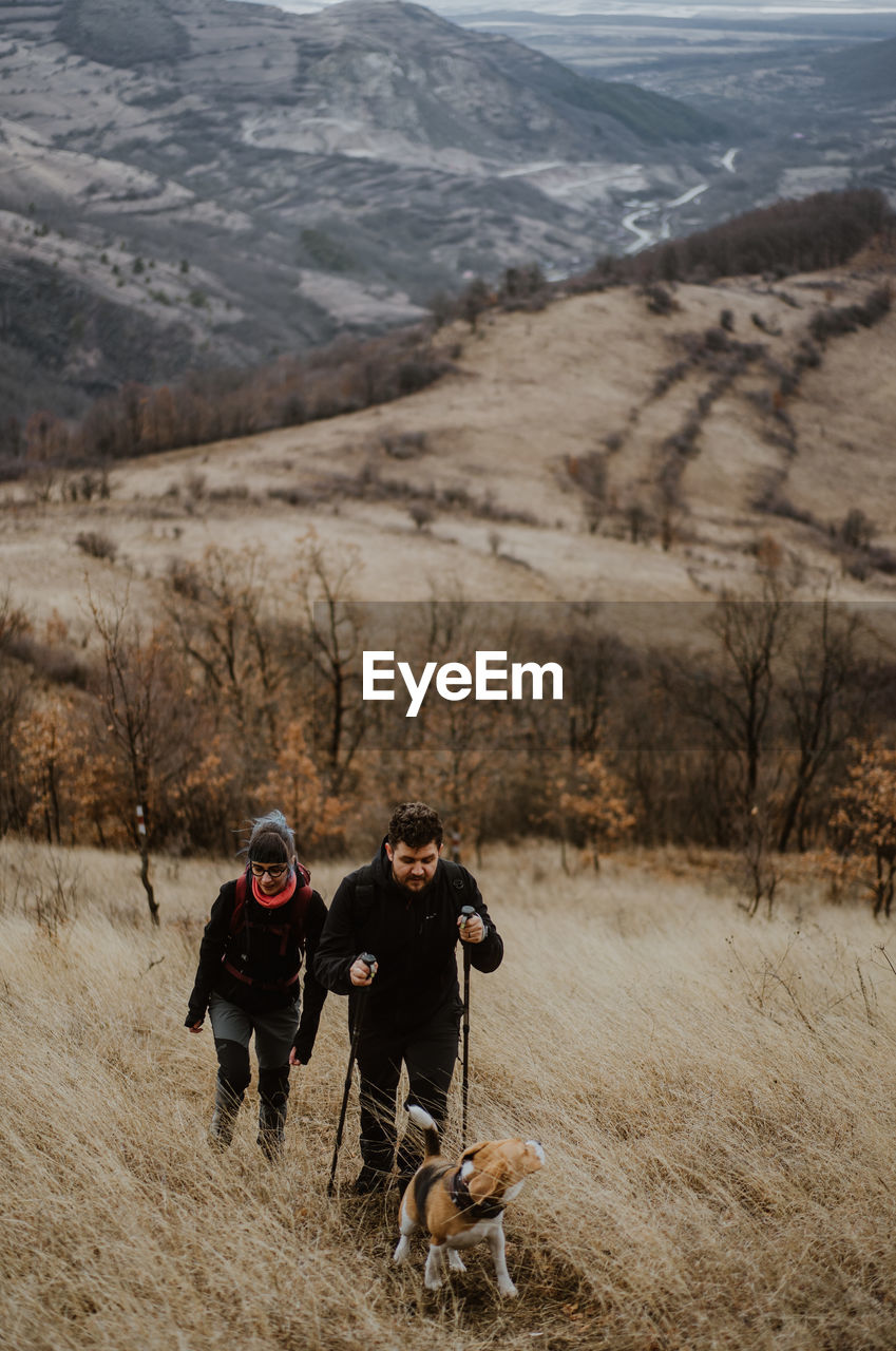 High angle view of couple with dog hiking on mountain