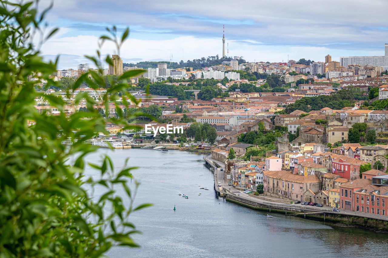 River amidst buildings in city against sky