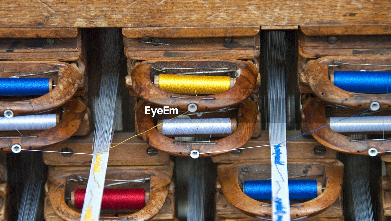 Close-up of threads on weaving machine at factory