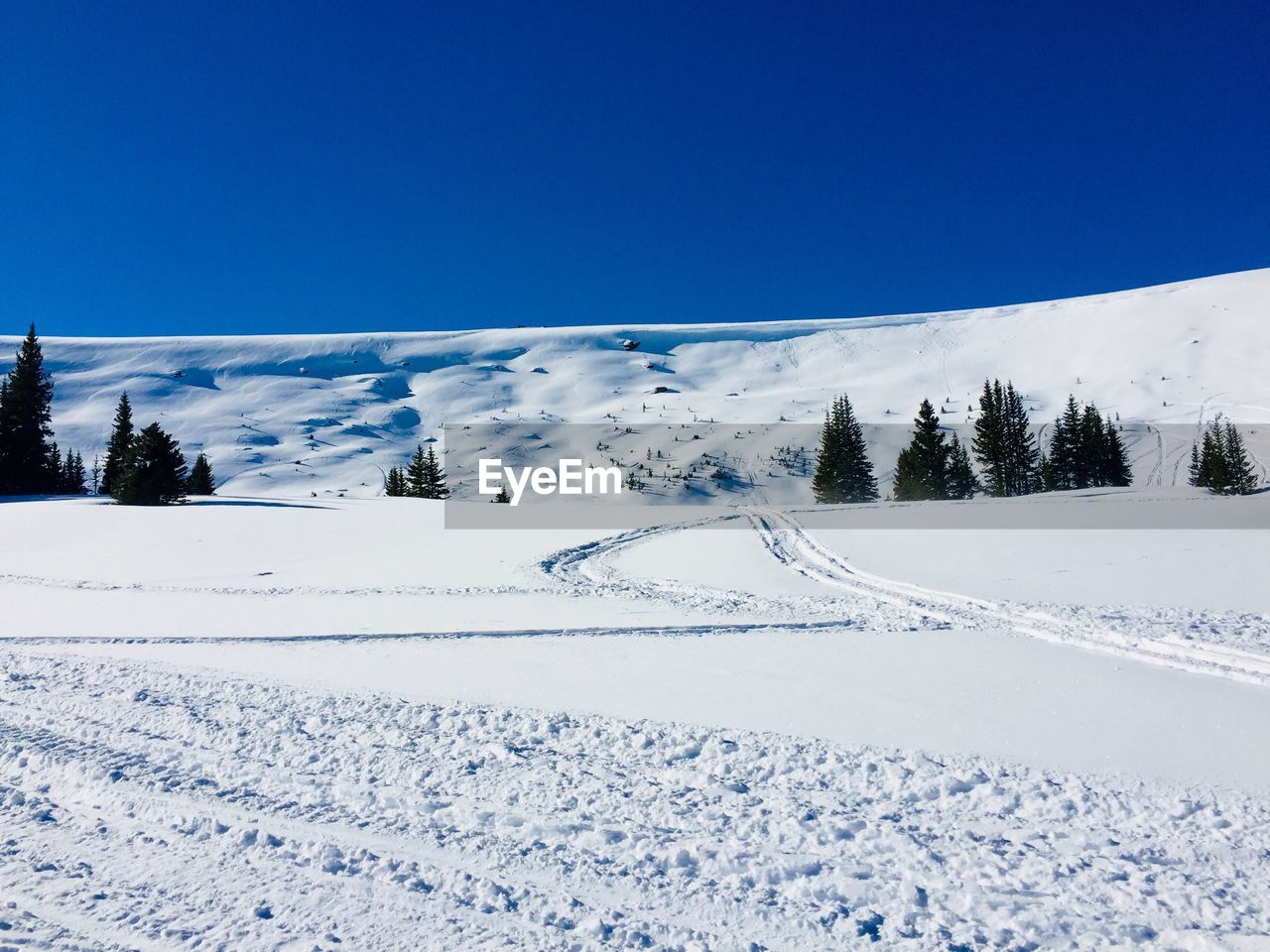 SNOW COVERED LANDSCAPE AGAINST BLUE SKY