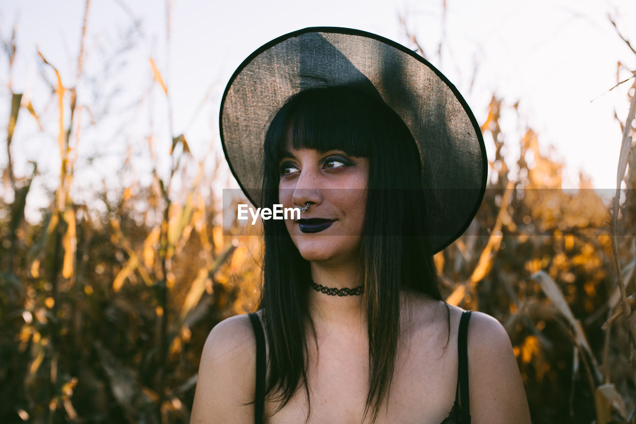 PORTRAIT OF YOUNG WOMAN WEARING HAT