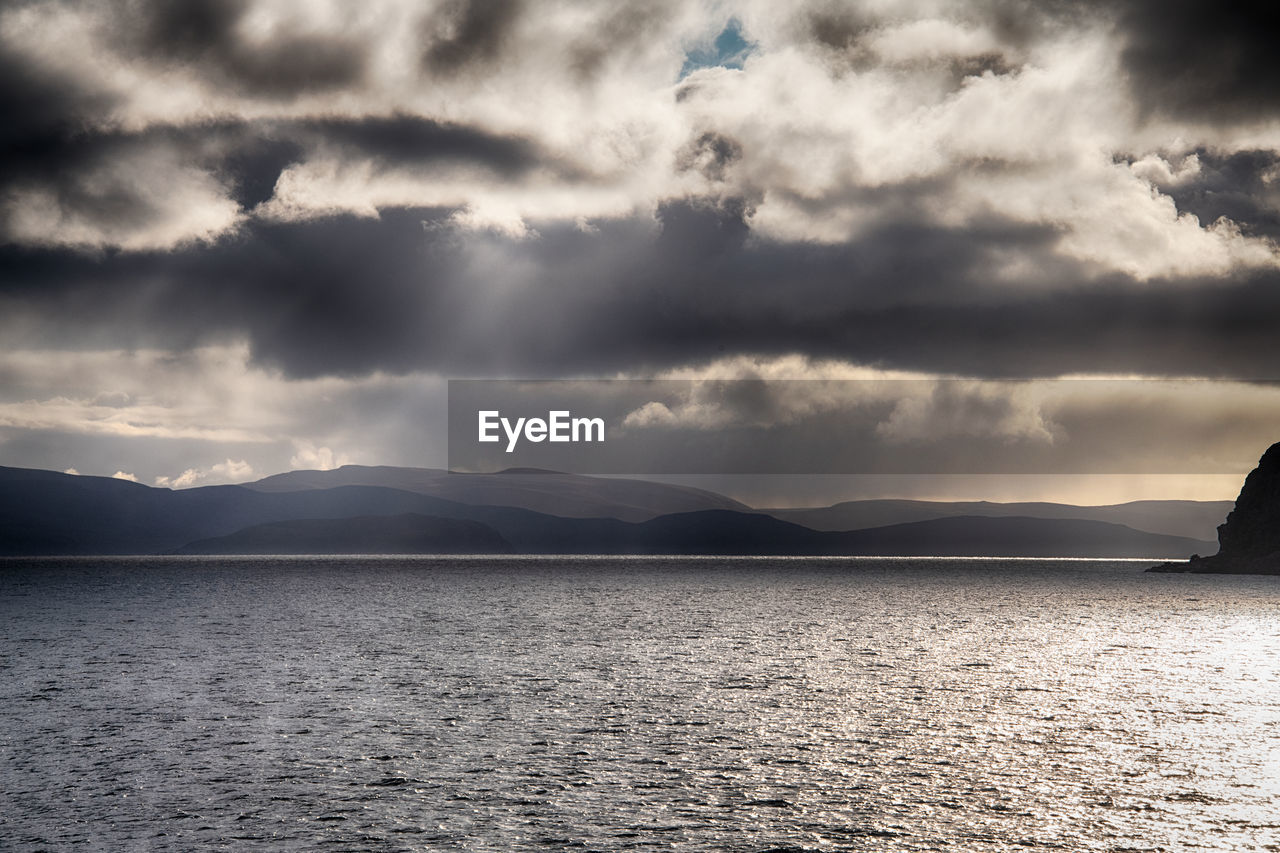 cloud, water, horizon, sky, beauty in nature, scenics - nature, mountain, sea, nature, environment, ocean, dramatic sky, reflection, black and white, sunlight, tranquility, monochrome, landscape, land, coast, dusk, tranquil scene, no people, storm, wave, darkness, shore, morning, cloudscape, monochrome photography, outdoors, storm cloud, mountain range, seascape, travel destinations, travel, beach, overcast, non-urban scene, moody sky, idyllic