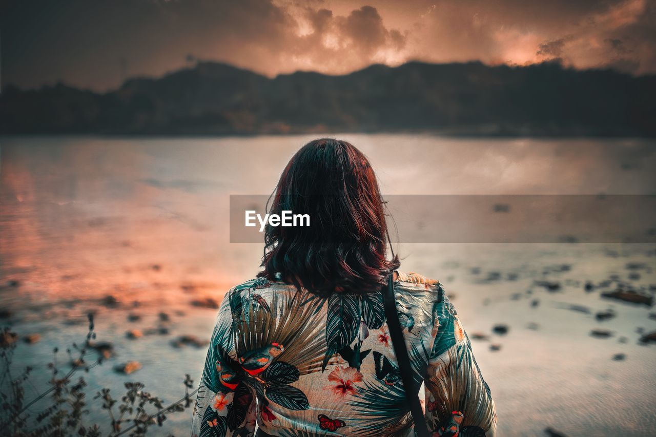 Rear view of woman looking at sea against sky