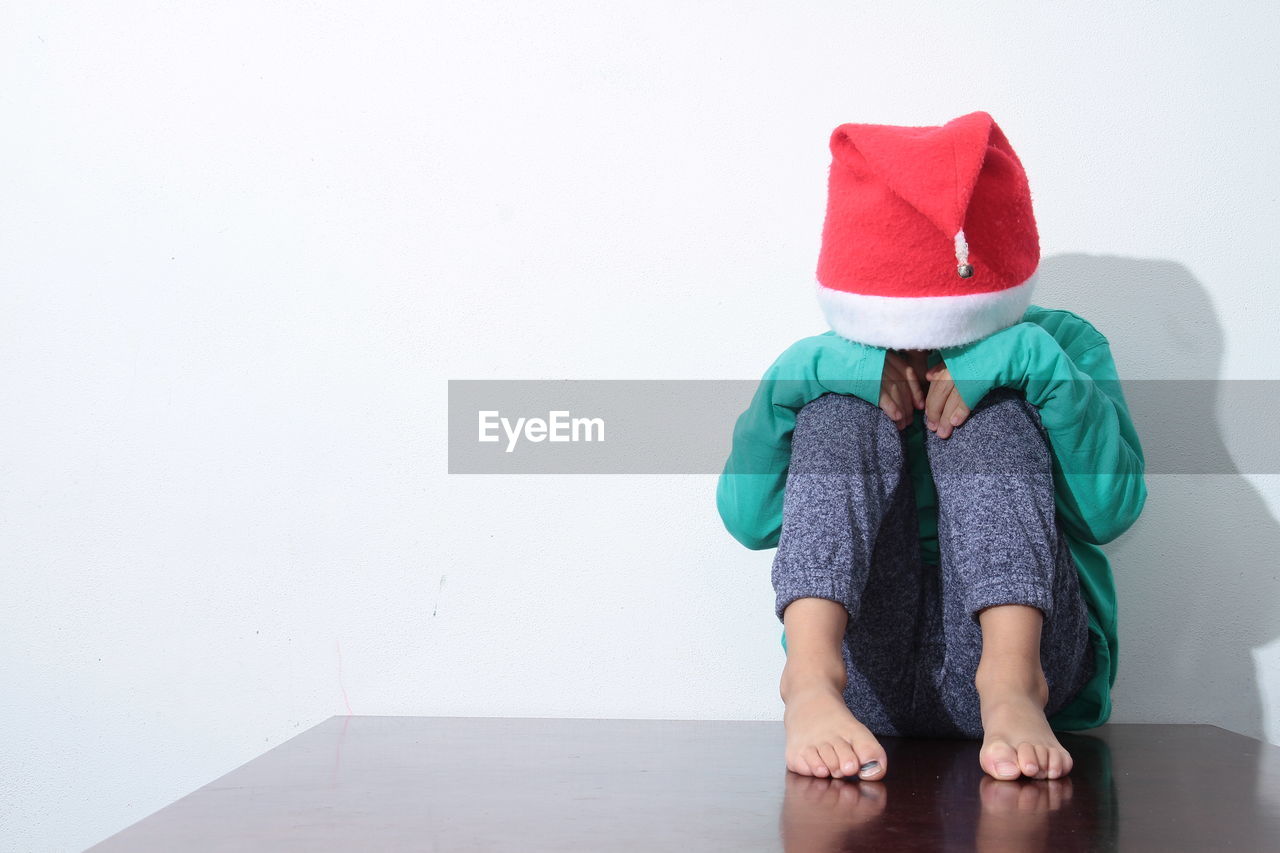 Little boy in poverty also praying and crying for food with no help with christmas hat stock photo