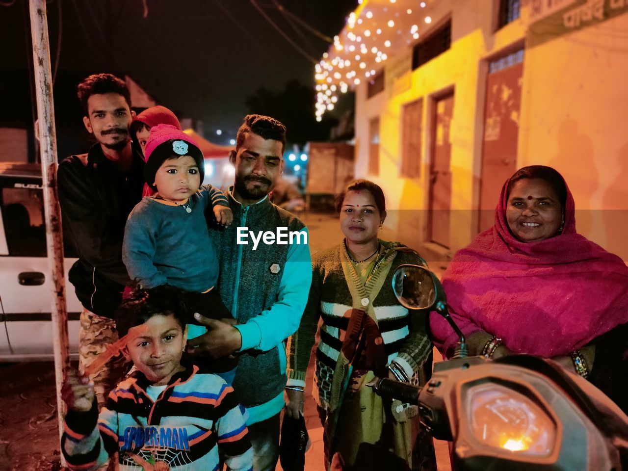 Happy family standing outdoors at night