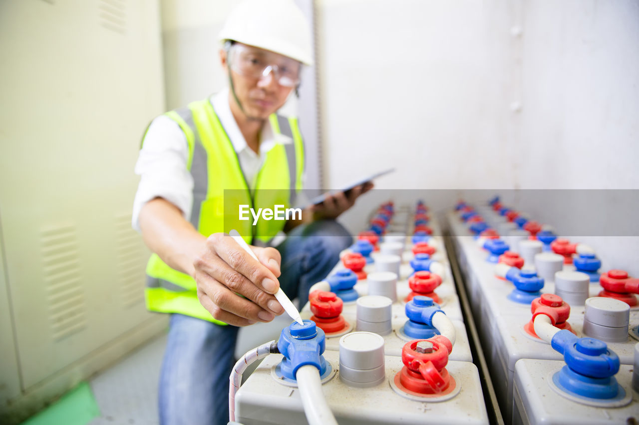 Man engineer in battery room in power plant for back up emergency case