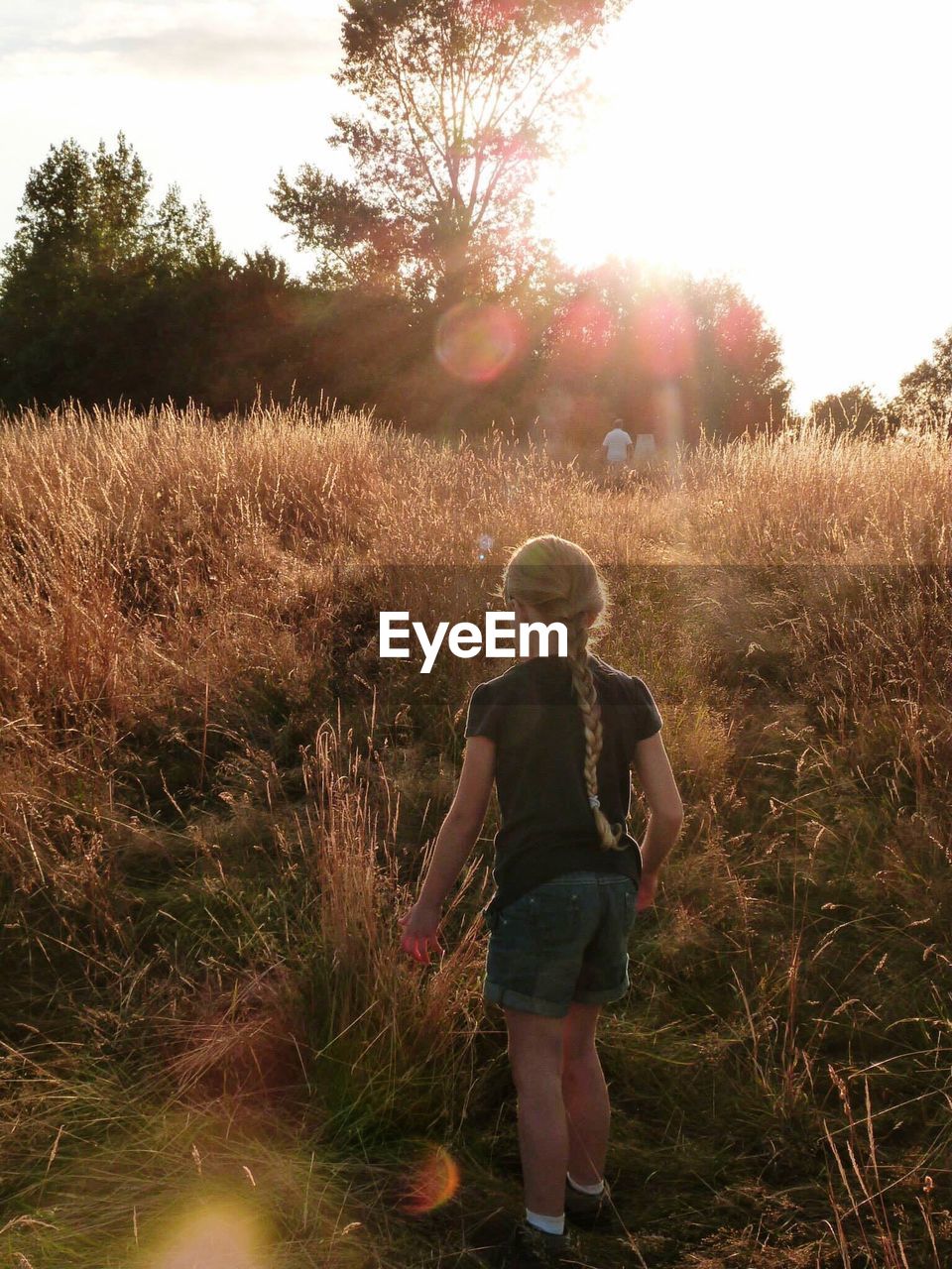 REAR VIEW OF WOMAN STANDING ON FIELD