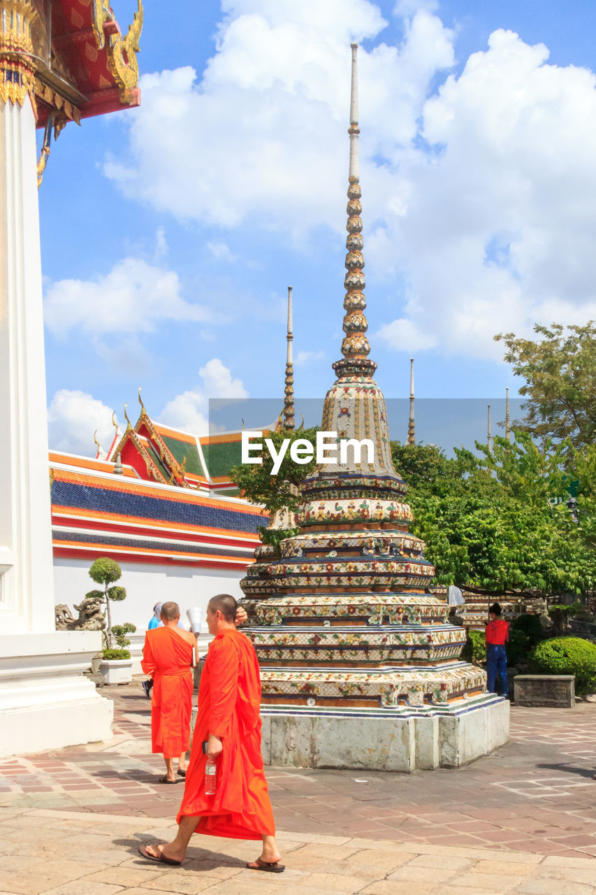 REAR VIEW OF MAN OUTSIDE TEMPLE AGAINST BUILDING