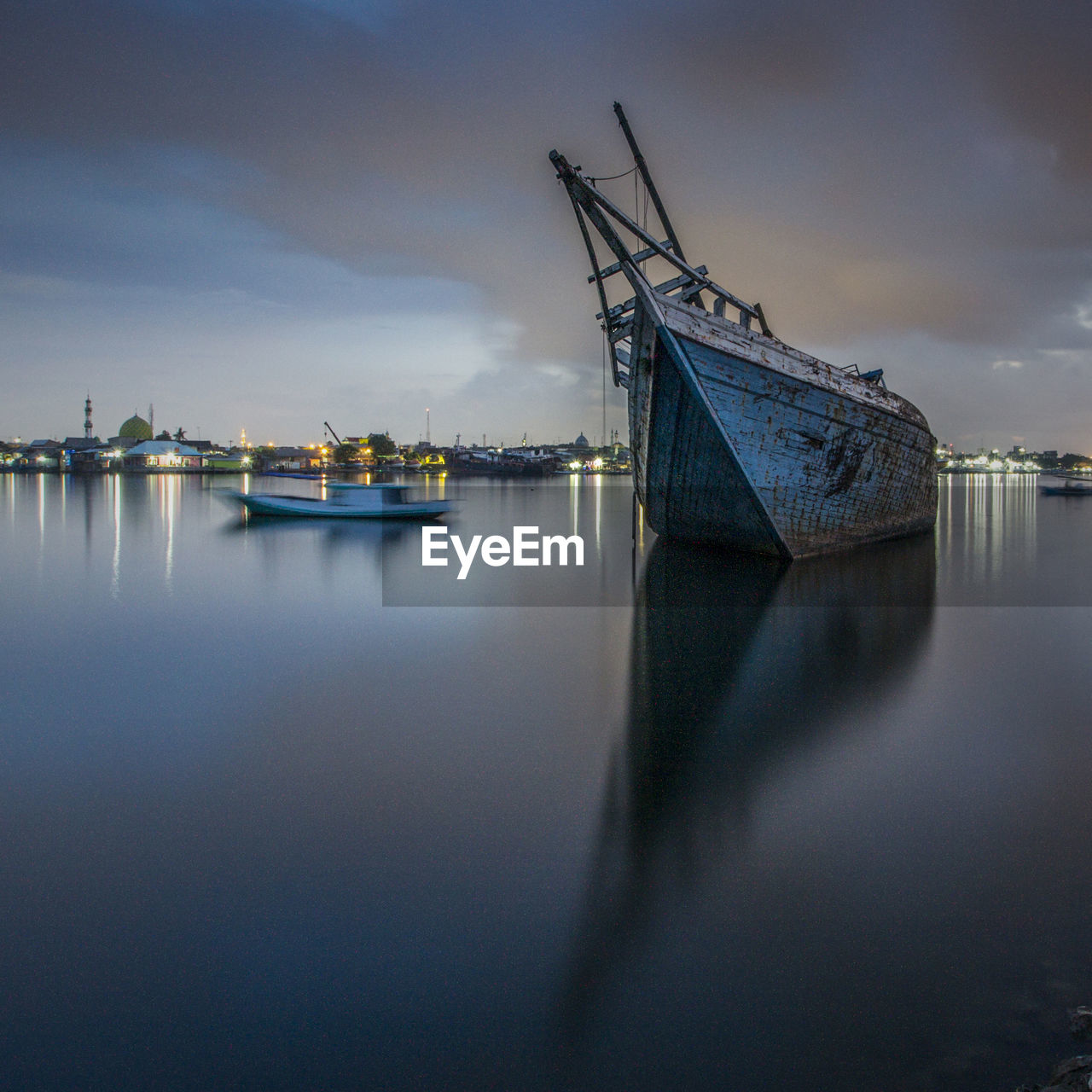 Boats moored in sea at dusk