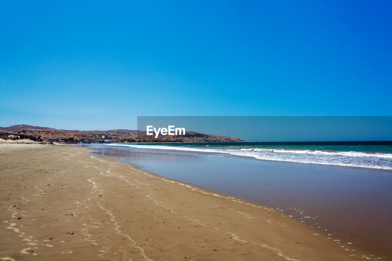 Scenic view of sea against clear blue sky on sunny day