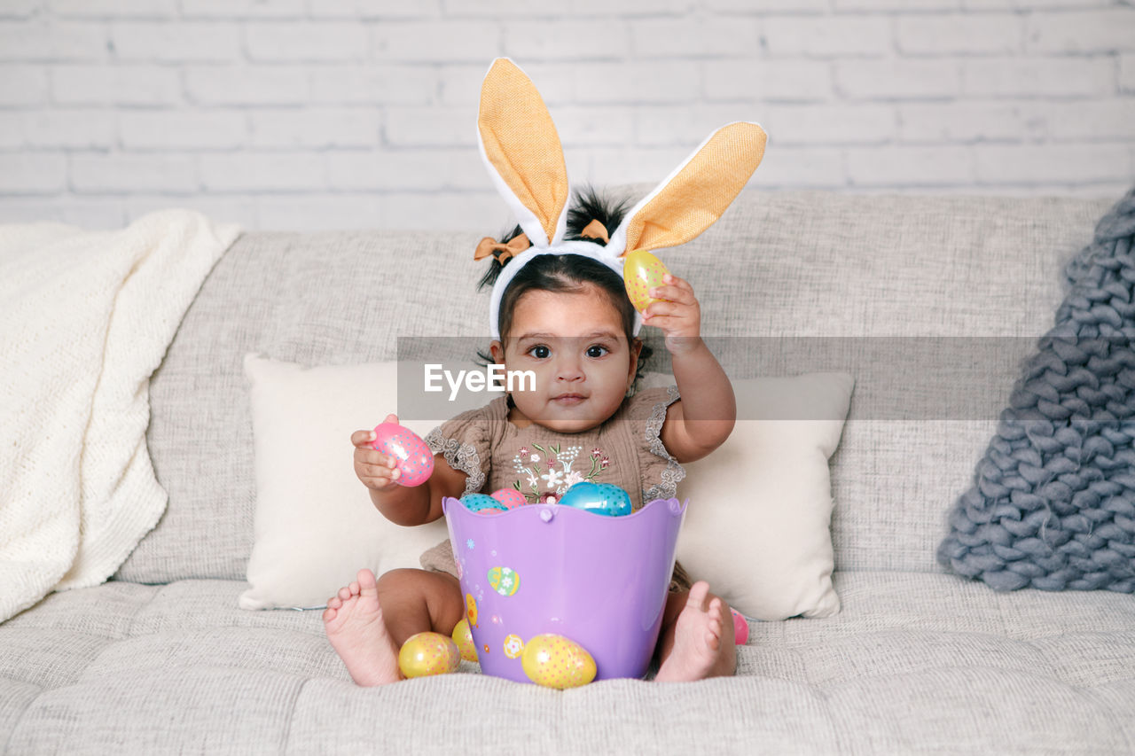 Cute girl wearing costume sitting on sofa