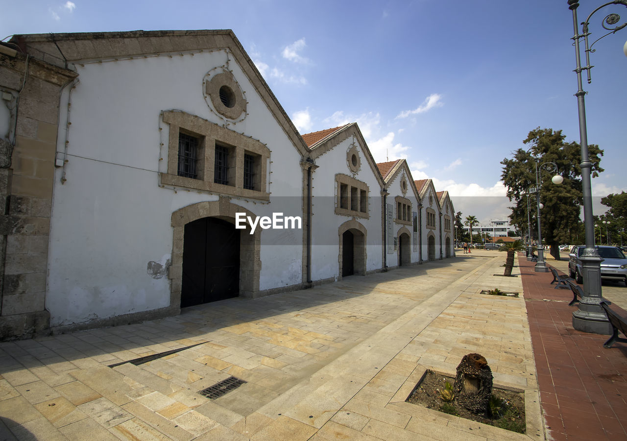 STREET BY BUILDINGS AGAINST SKY