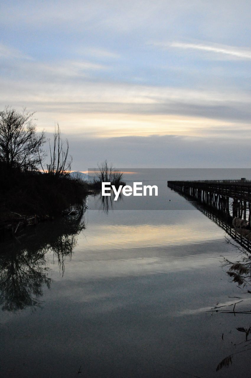 Scenic view of lake against sky at sunset